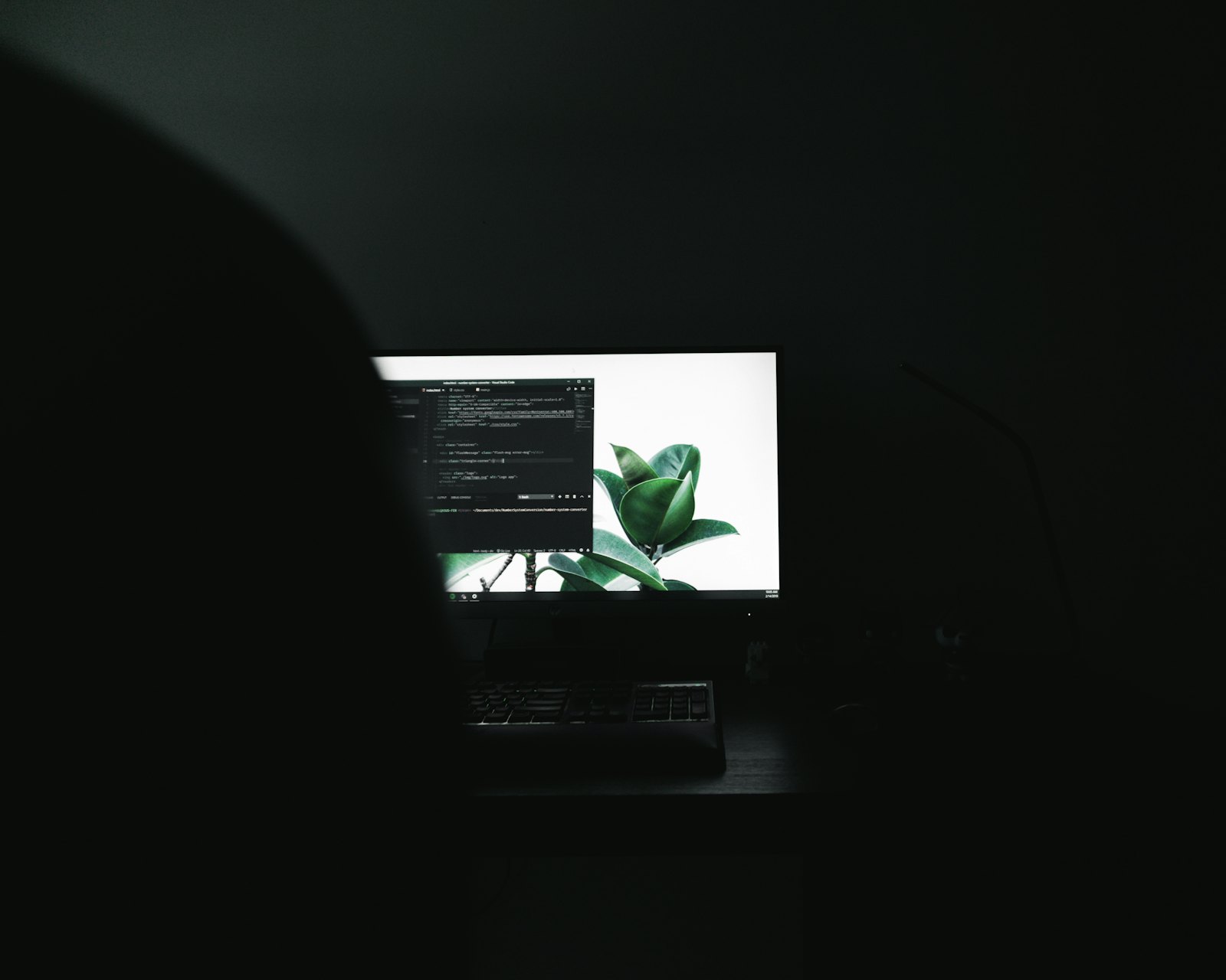 A single lit monitor in a dark room, late in the day